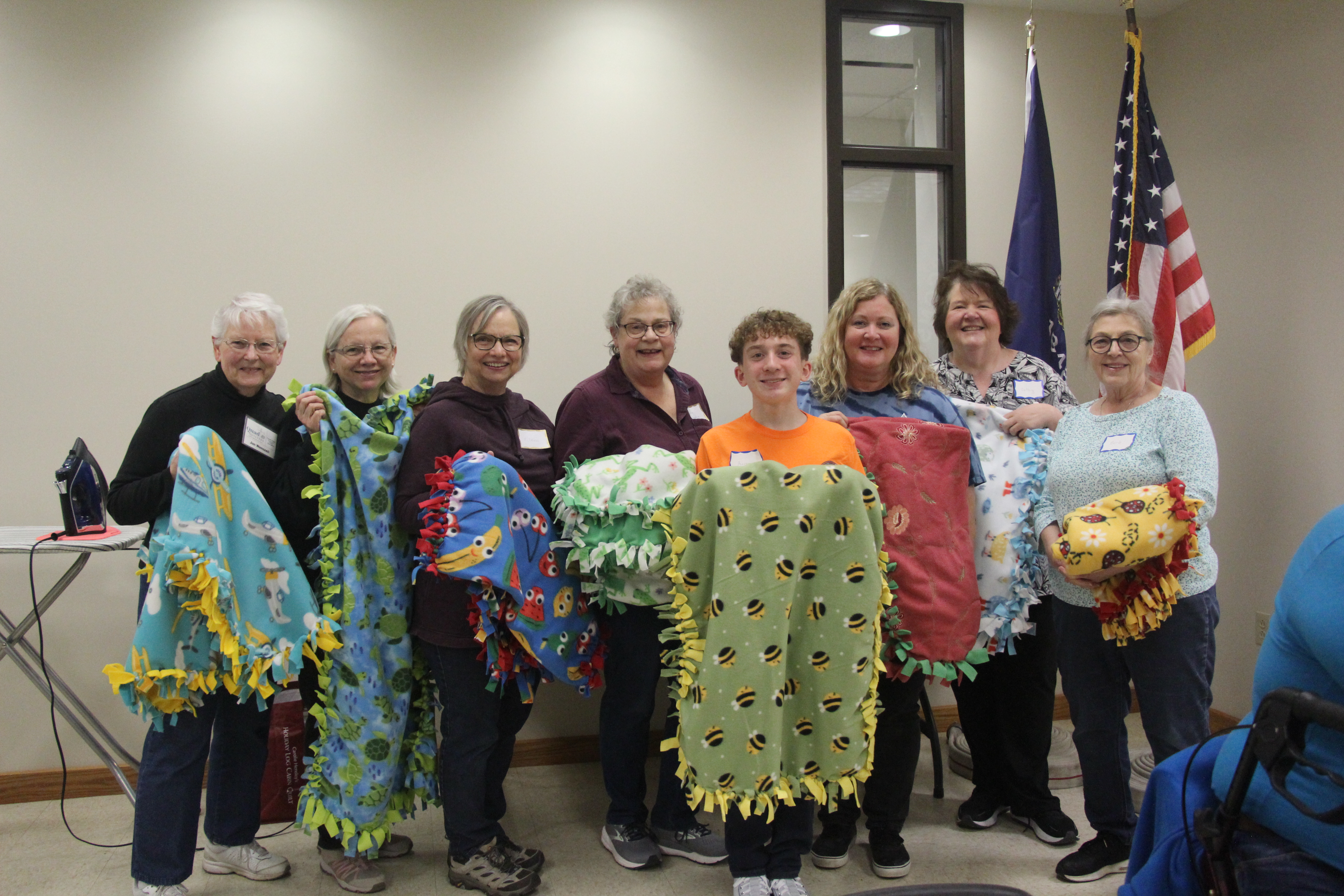 mutiple people holding tie blankets
